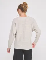 Buzo de punto calado en hilado fino, marca Allie Rose, de color gris. Presenta una silueta relajada con escote a la base, mangas largas de corte caído con puños ajustados y ruedo recto con pretina acanalada.