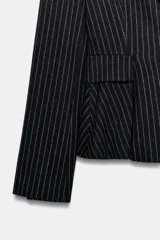 Blazer entallado con diseño peplum, confeccionado en tela con estampado de raya diplomática. Presenta cuello con solapas de muesca, cierre frontal con un botón, mangas largas y bolsillos delanteros con solapa.