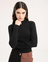 Polera negra de tejido de punto acanalado, con cuello alto y mangas largas.