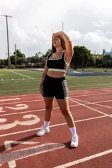 Short deportivo color crema con cintura elástica y rayas verticales marrones en los laterales.