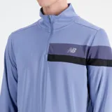 Buzo deportivo celeste de manga larga con cierre medio en el cuello. Presenta una franja horizontal en el pecho con el logo de la marca.