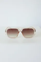 Lentes de sol con armazón de policarbonato negro y cristales tonalidad ámbar, con diseño de puente doble estilo aviador.