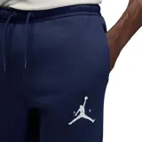 Pantalon de jogging Nike Jordan, confeccionado en tejido fleece color negro, con cintura elástica ajustable mediante cordón, puños elásticos en los tobillos y logo Jumpman bordado en color rojo en la pierna izquierda.