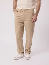 Pantalón de corte recto en color beige, confeccionado en mezcla de algodón y lino, con bolsillos laterales y trabillas para cinturón.