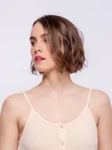 Vestido corto negro, sin mangas, con escote redondo y cierre frontal de botones.