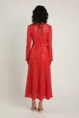 Vestido largo de crochet rojo con lentejuelas, escote en V profundo con detalle de cuerdas en el pecho y manga larga.