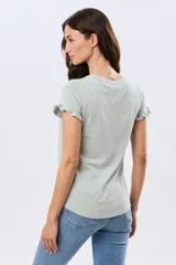 Remera de algodón color verde menta, con escote redondo y mangas corta con detalles de volados sutiles en los puños.