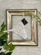 Microtanga blanca de encaje con tiras finas regulables.