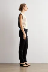 Pantalón slim de denim negro, con tiro medio, corte ajustado y bolsillos clásicos.