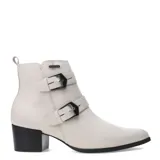 Botas de caña baja marca Bottero, confeccionadas en cuero color beige, con detalle de dos tiras con hebillas metálicas oscuras y taco cuadrado negro.