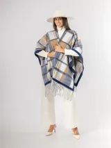 Ruana abierta con diseño de cuadros en tonos azul, beige y blanco, con terminación de flecos en el ruedo.