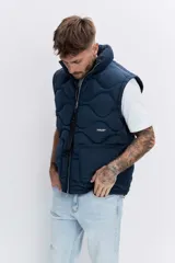 Cazadora acolchada de color azul marino con diseño de costuras onduladas, cierre frontal con cremallera y cuello alto. Presenta bolsillos frontales y un ajuste cómodo.