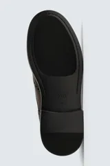 Zapato de vestir acordonado de cuero color marrón oscuro, con puntera brogue y suela de goma.