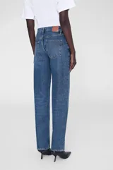 Pantalón de jean azul de corte recto, tiro alto y largo hasta el tobillo.