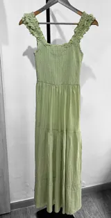 Vestido corto con textura elástica, escote recto con volados y corte debajo del busto.