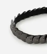 Cinturón femenino de estilo boho, compuesto por una serie de monedas metálicas interconectadas con acabado en tono gunmetal. Posee una estructura flexible con elástico interno para un ajuste cómodo.