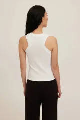 Musculosa de tejido acanalado blanco, de corte ajustado con cuello redondo y espalda deportiva.