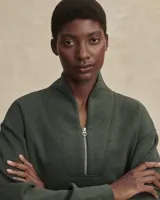 Buzo de tejido ligero DoubleSoft®, color verde oliva, con cuello alto y cierre frontal parcial. Presenta un corte ligeramente recortado, hombros caídos y puños pronunciados.