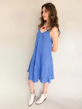 Vestido blanco de lino con breteles finos que se atan en los hombros.