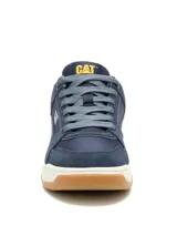 Championes Cat modelo Theorem, de estilo urbano inspirado en los años 90. Confeccionados en una combinación de ante y nylon, presentan un diseño en tonos azul marino con entresuela de EVA blanca y suela de goma color caramelo. Incluyen el logo de la marca en el lateral y la lengüeta.