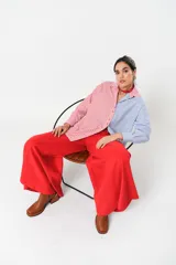 Camisa a rayas rojas y blancas en un lado y azules y blancas en el otro, con corte en A y abertura central con botonadura doble.