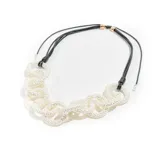 Collar corto con eslabones grandes de perlas sintéticas y cordón negro ajustable.