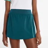 Pollera short deportiva de color verde petróleo, con diseño de cintura alta y detalle de línea vertical en tono verde claro. Cuenta con short interior incorporado y tejido de secado rápido.