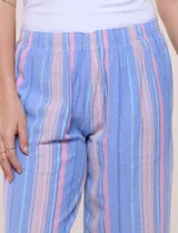 Pantalón de algodón rústico color verde, de tiro medio-alto con pretina elastizada y bolsillos laterales. Presenta corte holgado, diseño cropped de pierna ancha y aberturas laterales en los tobillos con detalles de botones.