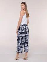 Pantalón crop ancho en color negro con estampado floral en contraste, bolsillos laterales y detalle de encaje en el ruedo.