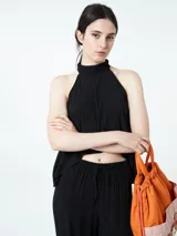 Top negro sin mangas con cuello alto.