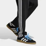 Pantalón deportivo Adidas Originals de la selección argentina, color negro con las icónicas tres tiras blancas laterales. Presenta el escudo de la AFA bordado en el muslo y corte clásico con cintura elástica y cordón de ajuste.
