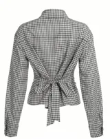 Camisa entallada de manga larga con estampado de cuadros, cuello clásico y cierre frontal con botones. Presenta un diseño con lazo regulable en la espalda para ajustar el calce a la cintura.