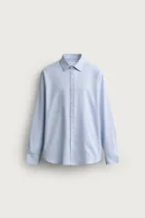 Camisa negra de corte regular fit, cuello italiano, manga larga con puño abotonado y cierre frontal con botones.