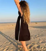 Vestido corto negro con panel lateral blanco, de corte holgado y mangas cortas con volados.