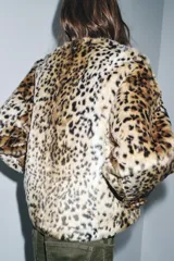 Chaqueta de Zara Woman Collection confeccionada en tejido efecto pelo con estampado animal print. Presenta cuello redondo, manga larga, bolsillos delanteros y cierre frontal con botones metálicos en relieve.