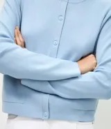 Cardigan de punto color marrón chocolate, con cuello redondo, cierre frontal con botones y mangas largas. Presenta un diseño clásico con acabado canelado en el escote y los puños.