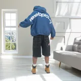 Bermuda baggy de denim negro con costuras en contraste blancas, bolsillos traseros grandes y un parche bordado en forma de estrella con la inscripción 'Venefo'.