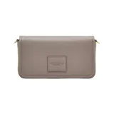 Cartera bandolera Marc Jacobs modelo The Mini Bag, confeccionada en cuero premium color beige. Presenta diseño rectangular con solapa frontal, logo grabado en el frente y correa ajustable con el nombre de la marca tejido.