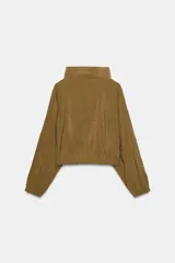 Chaqueta color naranja óxido de tejido fluido, con cuello subido, manga larga acabada en elástico, bolsillos laterales de vivo, bajo elástico y cierre frontal con cremallera.