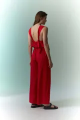 Mono rojo con cuello halter, corte holgado y pierna ancha.