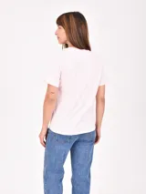 Remera de algodón color celeste con estampa frontal circular que incluye texto y diseño floral.