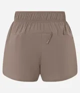 Bermuda deportiva Get Over modelo runner color beige, con cintura elástica, bajo redondeado y aberturas laterales. Cuenta con un pequeño bolsillo funcional trasero.