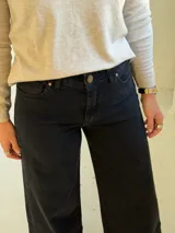 Pantalón de jean negro de corte wide leg con diseño de costura horizontal en el ruedo y terminación deshilachada. Cuenta con cierre frontal y bolsillos laterales.