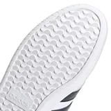 Championes urbanos Adidas modelo Barreda, de silueta baja y estilo clásico inspirado en el tenis. Presentan una capellada de cuero sintético blanco con refuerzos de gamuza en la puntera, las icónicas tres tiras laterales en color negro y suela cupsole de goma.