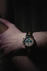 Reloj de pulsera Chenaut Aurum para hombre, con caja de acero inoxidable negra y esfera de madera de zebrano. La malla es de acero inoxidable negra con detalles en madera de bambú. Tiene cronógrafo, indicador de 24 horas y fechador.