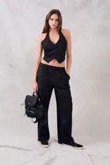 Pantalón negro de lino y viscosa, de tiro medio y corte recto, con cintura elástica.