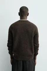 Jersey de punto regular fit, confeccionado en una mezcla de lana y fibra de alpaca. Presenta cuello redondo, manga larga y acabados en rib en puños y bajo.