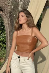 Top corto de cuero color marrón, con tirantes finos y escote recto.