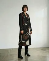 Tapado largo de diseño de autor con silueta estructurada y solapas clásicas. Presenta una estampa orgánica abstracta en tonos tierra, beige y negro, con mangas largas lisas en color negro. Cuenta con forro térmico interior para mayor abrigo.