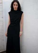 Vestido midi de tejido fluido con diseño evasé, cuello perkins y sin mangas. Presenta detalle de cintura drapeada y cierre de cremallera en la parte posterior. Incluye forro interior.